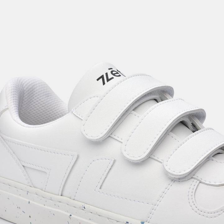 Zoom sur les baskets blanches Alpha avec fermeture à scratchs, finitions soignées et matériaux recyclés