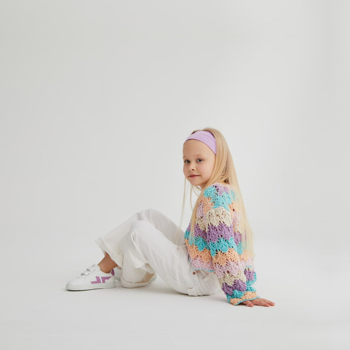 Children's trainers being worn. White and purple velcro trainers